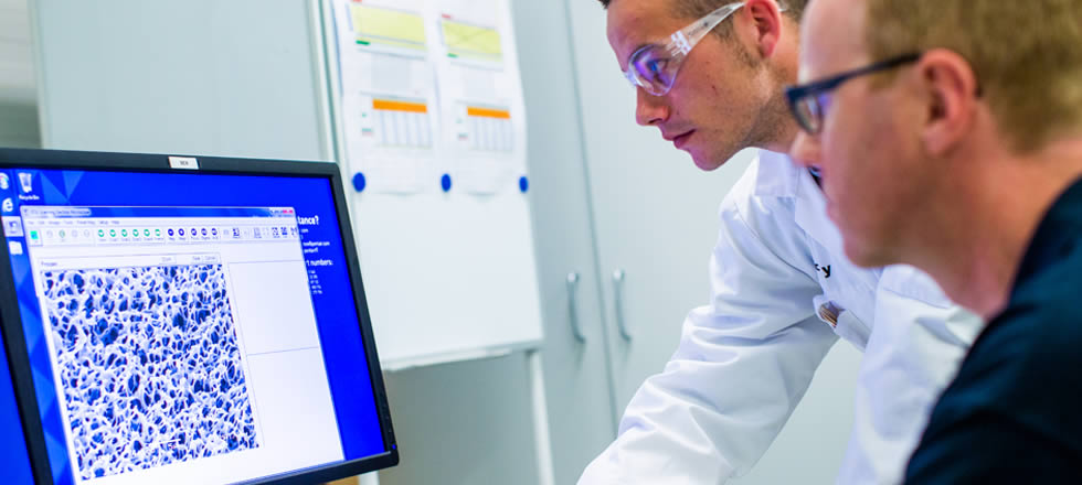 Hero Image Two lab employees looking at screen