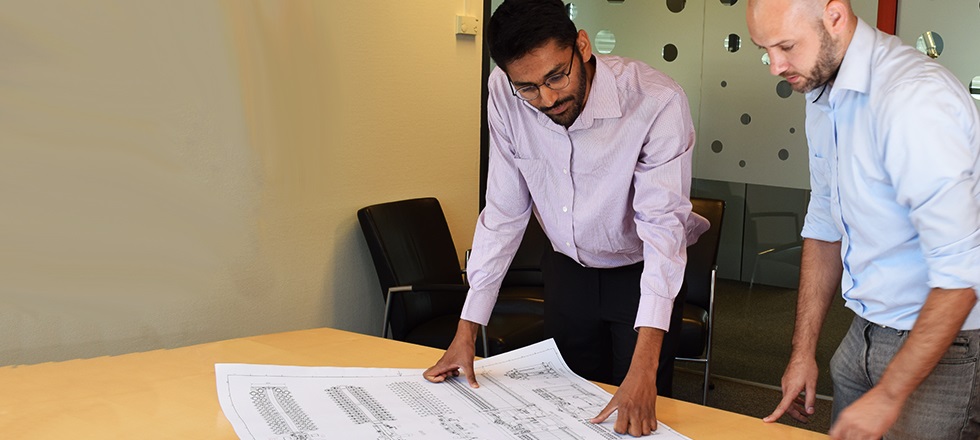 Hero Image Two employees looking at drawing